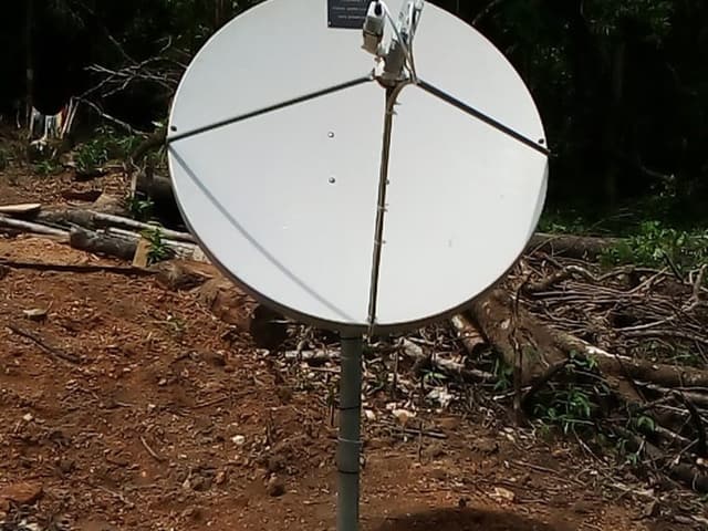 Antenne satellite bande Ku de 1,2 m sur mât dans une clairière forestière à Mbaloma, Foya