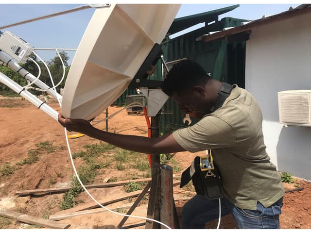 Ingénieur de Global IT Firm alignant une antenne satellite bande Ku sur un mât