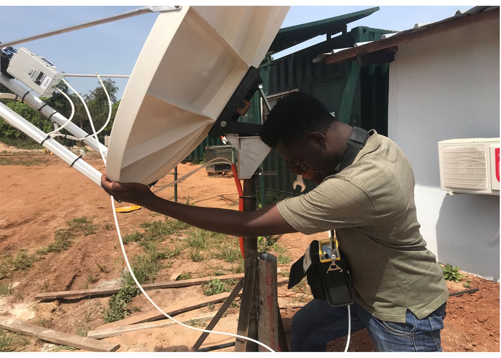 Ingénieur de Global IT Firm alignant une antenne satellite bande Ku sur un mât