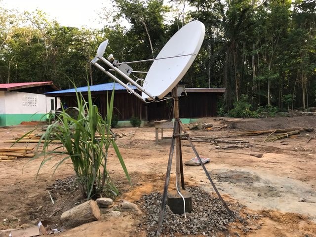 Antenne satellite Ku de 1,2 m sur trépied dans un camp défriché en forêt, pour Kris International Liberia