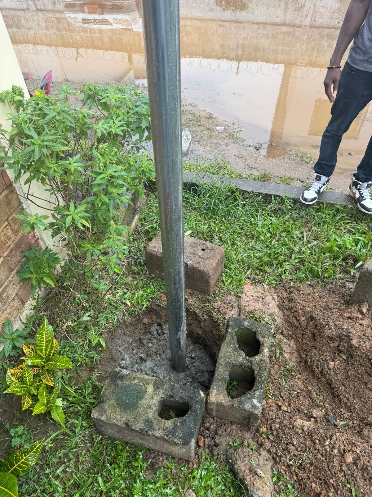 Starlink mast set in a block foundation beside an office building in Monrovia (August 2026)