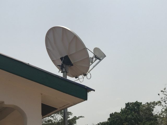 Antenne satellite Ku fixée en bord de toit avec une vue dégagée vers le satellite, sur le site de Let Them LOL en Sierra Leone
