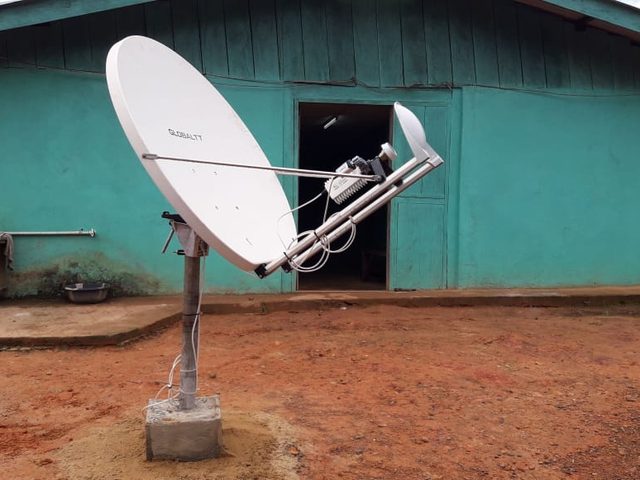 Antenne satellite Ku de 1,2 m sur mât à socle en béton devant un bâtiment du site de Mandra Forestry, dans le comté de Sinoe