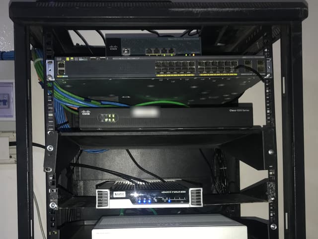 Baie réseau au bureau du HCR à Saclepea avec un contrôleur sans fil Cisco, un commutateur Cisco, un routeur Cisco 4300 et un modem satellite Newtec MDM3310