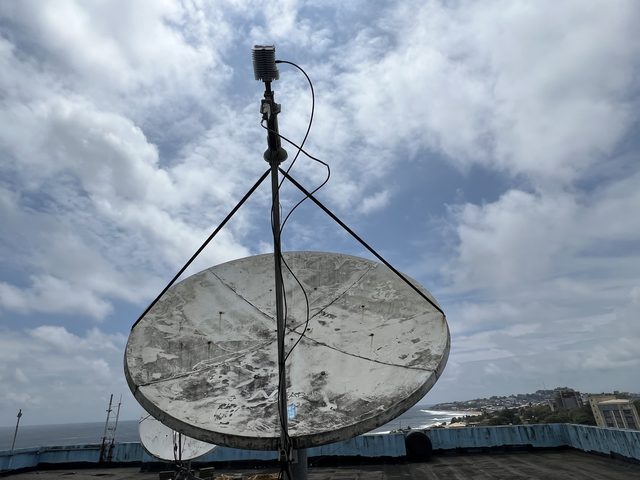 Antenne satellite de l'OMS sur le toit de One UN House, avec la côte de Monrovia en arrière-plan