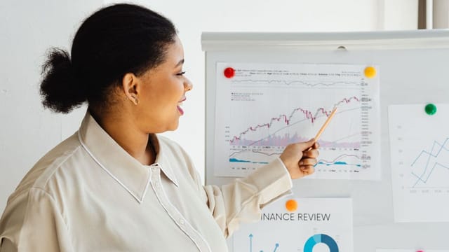 Analyst pointing to trends on a chart during a finance review