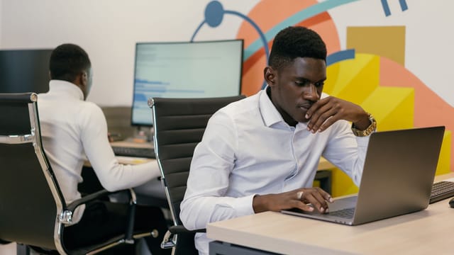Developers working at laptops and desktop screens in a modern office