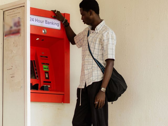 Homme utilisant un distributeur automatique de billets ouvert 24 h/24 à Lagos, au Nigeria