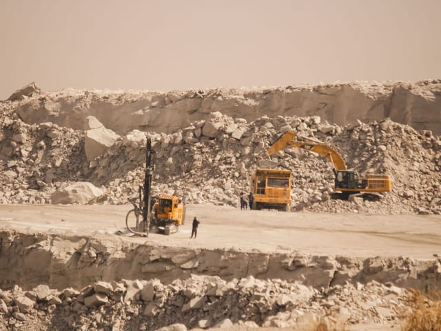 Excavator, dump truck and drilling rig working in a quarry in Kaduna, Nigeria