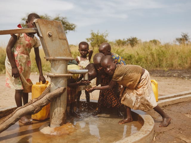 Children collecting water at a hand pump in Kitgum, Uganda