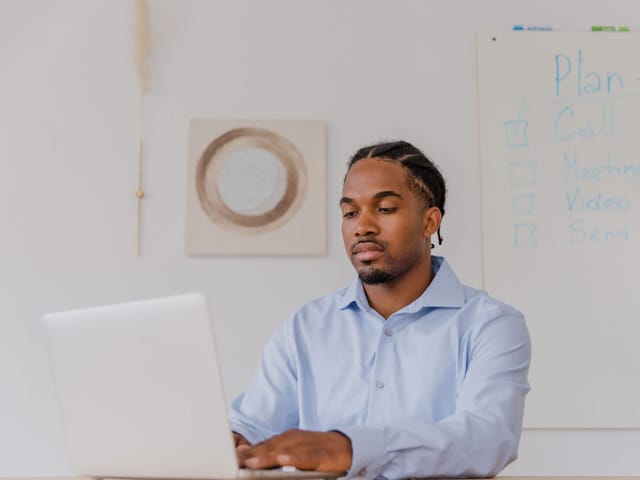 Man typing on a laptop at an office desk