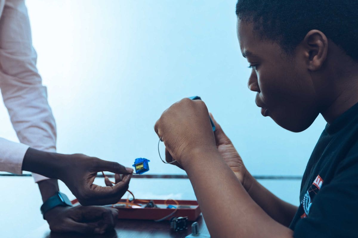 Élève branchant des composants électroniques lors d'un atelier technologique pratique