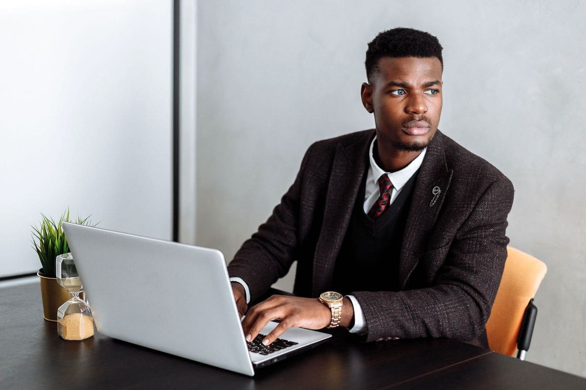 Professional in a suit working on a laptop at a desk