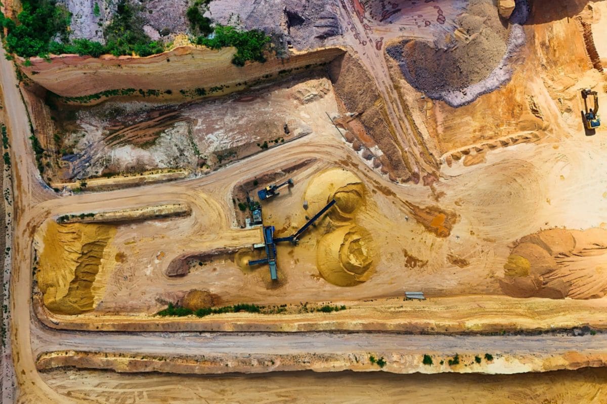 Aerial view of an open quarry with heavy machinery and processing equipment
